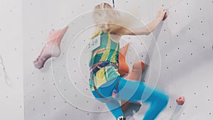 Little girl is climbing a training wall