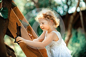Little girl climbing in treehouse at forest park, Active kid on playground, Child enjoying activity in a climbing adventure park