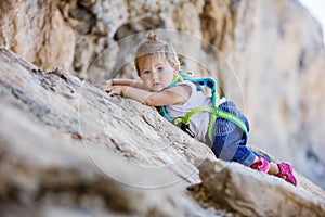 Little girl climbing up cliff