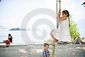 Little girl climbs on a big rope in the outdoor