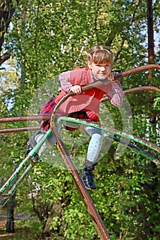 Little girl climbs and smiles on playground