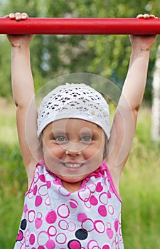 The little girl clings to crossbar