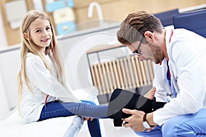 Little girl in clinic having a checkup with orthopaedist photo