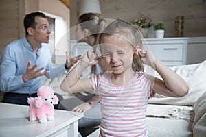 Little girl close ears refuse to hear family fight