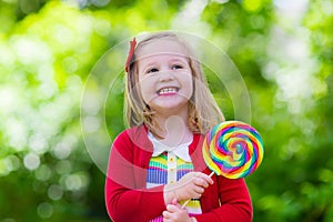 Little girl with colorful candy lollipop