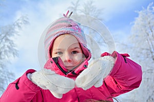 Little girl with colorful woolen cap and white woolen gloves