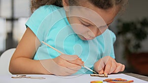 Little girl coloring craftwork at home