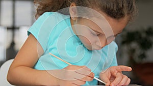 Little girl coloring craftwork at home