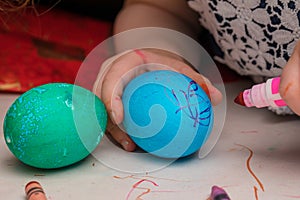 Little girl coloring Easter eggs