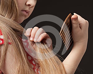 Little girl combing her beautiful long hair