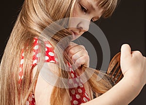 Little girl combing her beautiful long hair