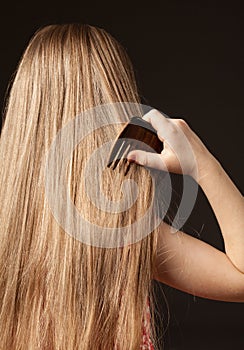 Little girl combing her beautiful long hair