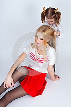 Little girl combing her hair beautiful mother