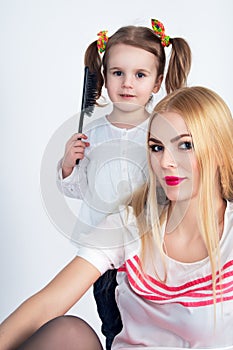 Little girl combing her hair mom