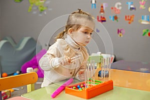 Little Girl Concentrated on Bead Sorting Activity