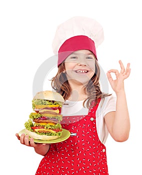 Little girl cook with big hamburger and ok hand sign