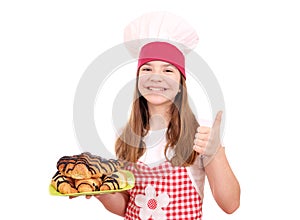 Little girl cook with croissant and thumb up