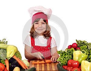 Little girl cook cutting carrot