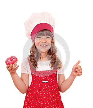 Little girl cook with donuts and thumb up