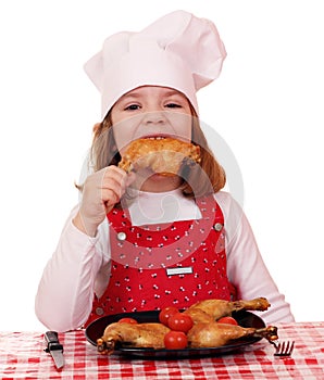 Little girl cook eat chicken drumstick photo