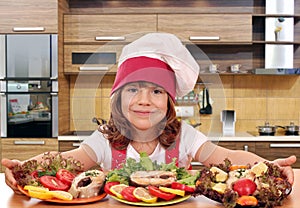 Little girl cook with prepared salmon seafood in kitch