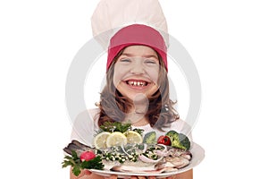 Little girl cook with prepared trout fish on plate