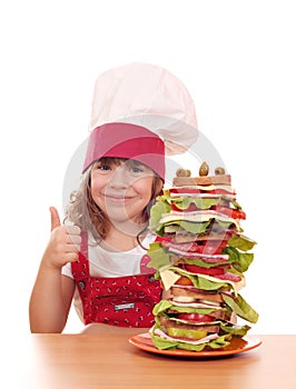 Little girl cook with sandwich and thumb up