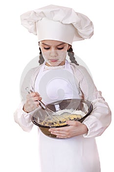 Little girl cook whips whisk eggs in a large plate photo