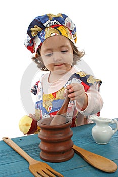 Little girl cooking dressed as a chef