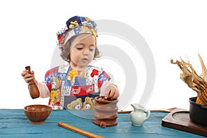 Little girl cooking dressed as a chef