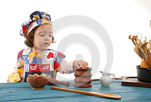 Little girl cooking dressed as a chef