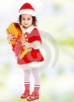 Little girl in costume of Santa Claus with gift