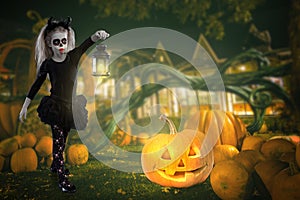 Little girl in a costume of witch posing with pumpkins over fairy background. halloween