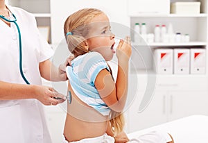 Little girl coughing at the doctor photo