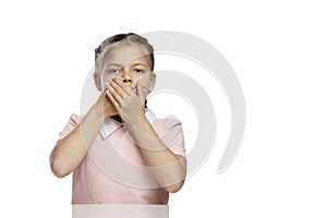 The little girl covered her mouth with her hands. Isolated over white background