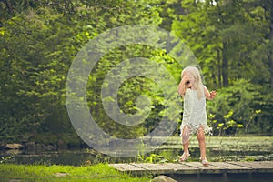 Little girl covering face and crying on bridge