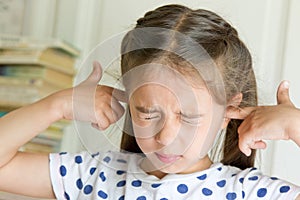 Little girl covering her ears