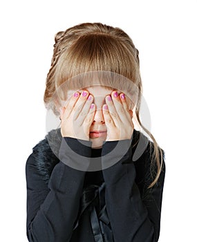 Little girl covers her face with hands