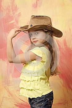 Little girl in cowboy or cowgirl outfit with hat