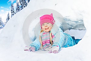 Little girl crawl through snow tunnel in park