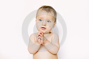 Little girl with cream on her baby`s face smiling on white background