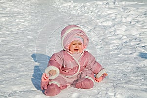 The little girl cries sitting on snow