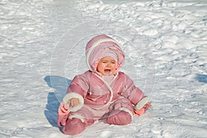 The little girl cries sitting on snow photo