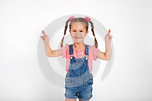 Little girl crossed her fingers, shut her eyes and makes a wish, isolated on white background