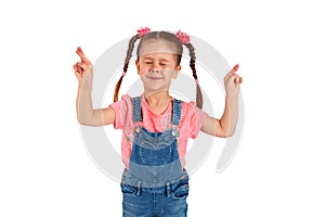 Little girl crossed her fingers, shut her eyes and makes a wish, isolated on white background