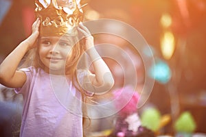 Little girl with crown at head playing at  birthday party