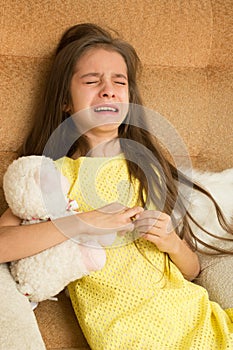 Little girl crying on a chair