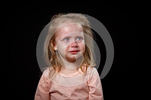 The Little Girl Is Crying Loudly, She Is Very Upset, She Is Hysterical. She Can& x27;t Calm Down. Photo In The Studio On A Dark