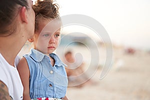 Little girl crying Mother daughter summer beach. Child upset and cry