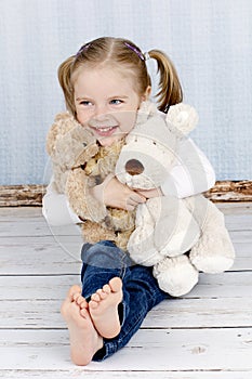 Little girl cuddling with plush toys